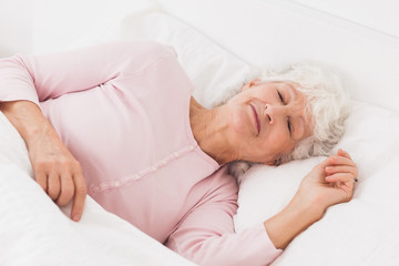 Obraz na płótnie Canvas Kobieta śpi w łóżku