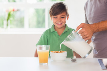 Obraz na płótnie Canvas Ojciec wprowadzenie mleka w kasze syna