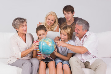 Fototapeta na wymiar Rodzina patrzy na świecie na kanapie