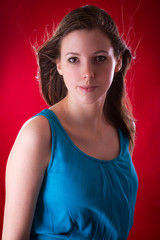 Portrait of young beautiful brunette over red background