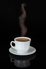 Kawa w białej filiżance na czarnym tle, para w kształcie dziewczyny.