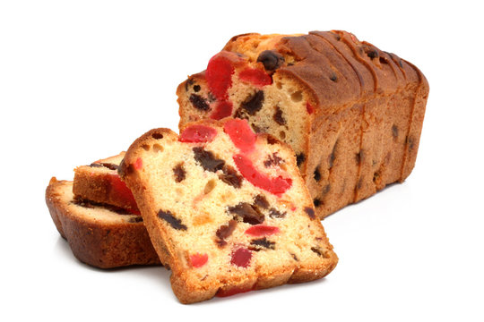Slices of traditional fruit cake with candied fruit, cherries and raisins isolated on white background