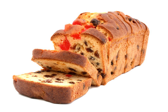 Slices of traditional fruit cake with candied fruit, cherries and raisins isolated on white background