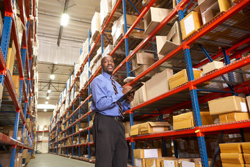 Businessman With Clipboard In Warehouse