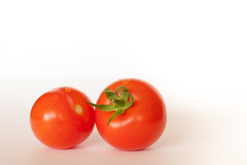 Two tomatoes isolated on white background