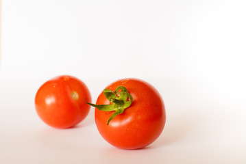 Two tomatoes isolated on white background