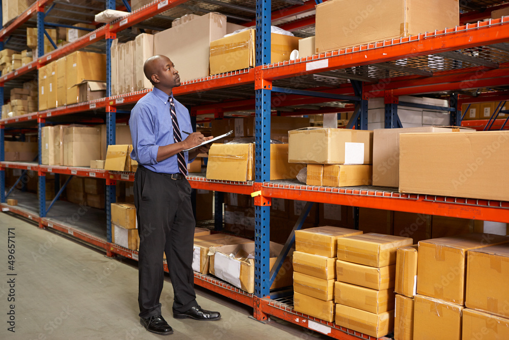 Wall mural businessman with clipboard in warehouse