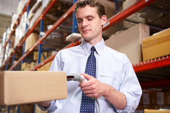 Businessman Scanning Package In Warehouse