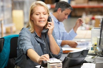 Businesswoman Working At Desk In Warehouse