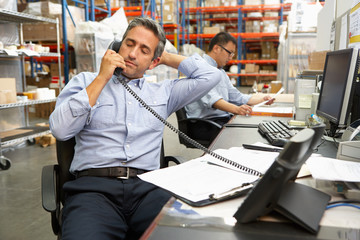 Businessman Working At Desk In Warehouse