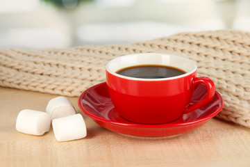 cup of coffee with scarf on table in room