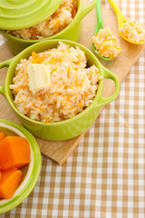 Taste rice porridge with pumpkin in saucepans