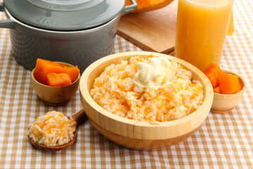Taste rice porridge with pumpkin and glass of juice