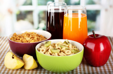 Delicious and healthy cereal in bowls with juice and fruit