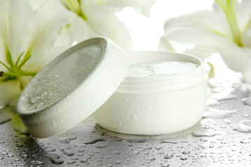 Obraz na płótnie Canvas Cosmetic cream and beautiful lily, close up