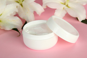 Cosmetic cream and beautiful lily, on pink background