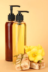 Liquid and hand-made soaps on beige background