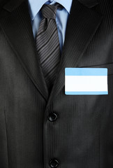 Blank nametag on businessman's black suit close up