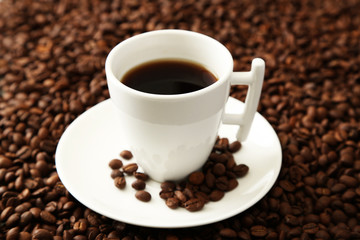 Cup of coffee on coffee beans background