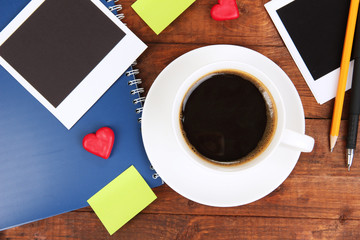 Cup of coffee on worktable covered with photo frames close up