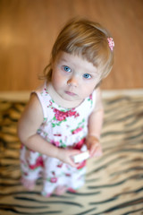 Beautiful little girl in a dress at home