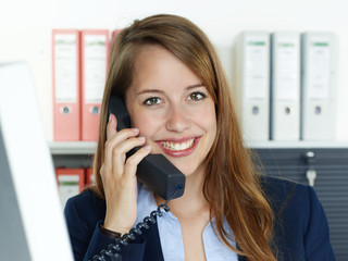 Female office assistant has a call at the office
