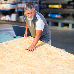 Senior man buying construction wood in a  DIY store