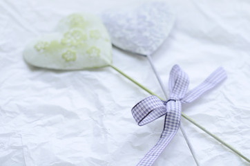 Tender green and lavender decorative hearts on light background