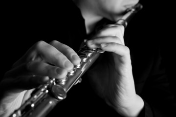 professional flutist musician playing flute on black background - obrazy, fototapety, plakaty