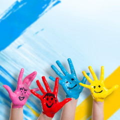 lachende Kinderhände vor Farbwand