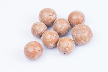 unshelled macadamia nuts on white background