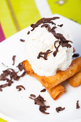 fried leche flan topped with ice cream and chocolate shavings