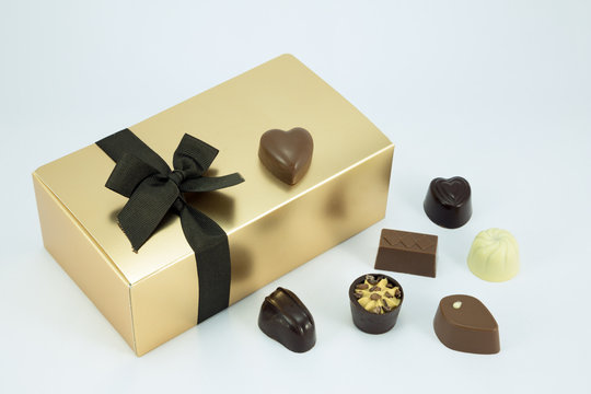 Gold chocolate box and assorted chocolates.