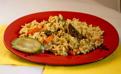 Pilaf rice and beef and a slice of salted pickles sauce