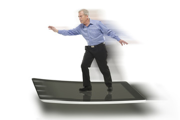 Senior businessman keeping balance on a PC tablet