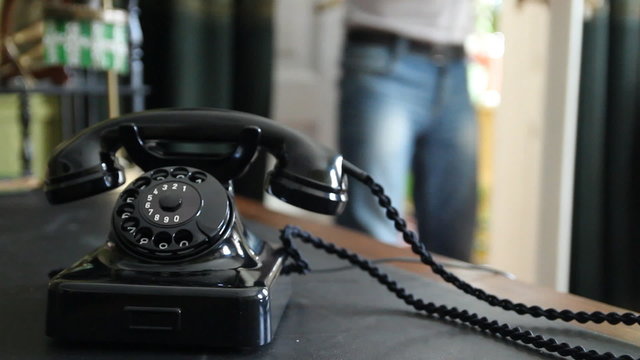 Vintage black telephone. Man dials 