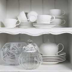 pure white cup  with plate , standing in white cupboard