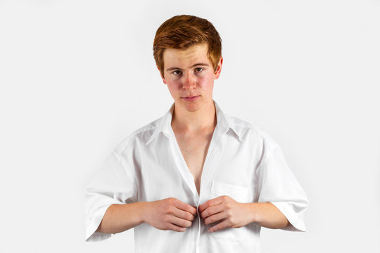 young man buttons his white shirt