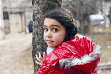 Girl in red jacket and a tree.