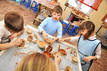 .group of children shaping clay in pottery studio