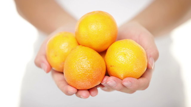 Clementine - woman shwoing clementines mandarin orange