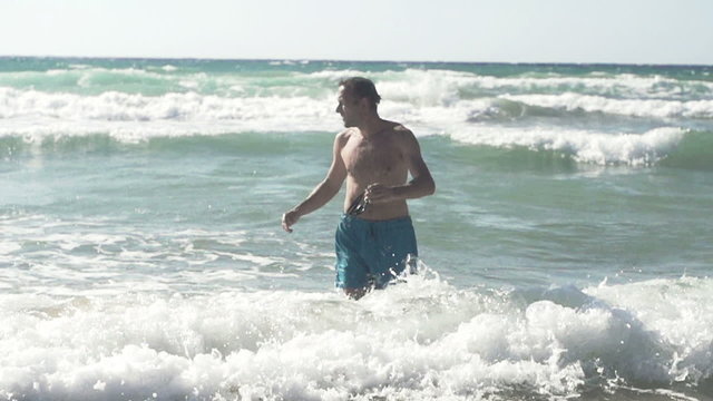 Man walking out of the sea, super slow motion