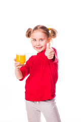 Cute little girl holding glass with juice smiling
