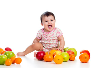 Fototapeta premium happy baby girl sitting among fresh fruits