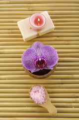 orchid with natural handmade soap and salt in spoon on mat