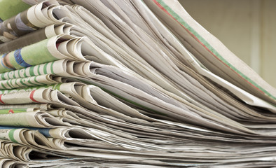 closeup pile of newspaper on wooden background