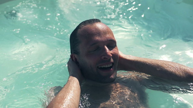 Man relaxing in swimming pool, slow motion shot at 240fps