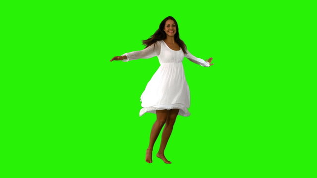 Girl in white dress twirling on green screen