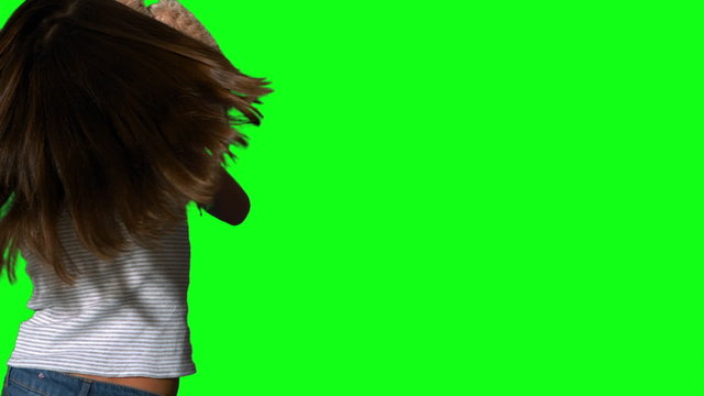 Little girl twirling and holding teddy on green screen