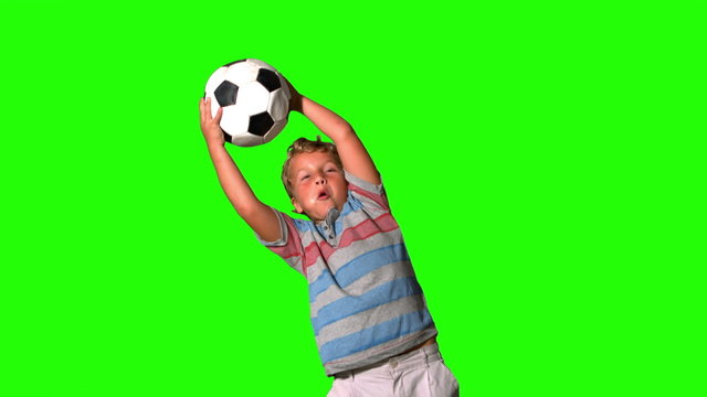 Boy catching football on green screen